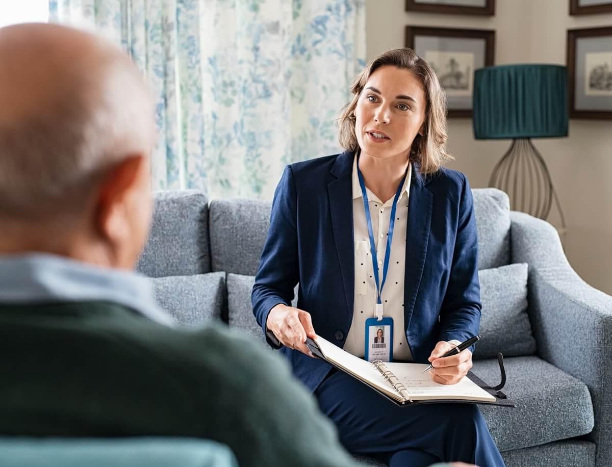 Female 社会工作er Speaking with Elderly Client